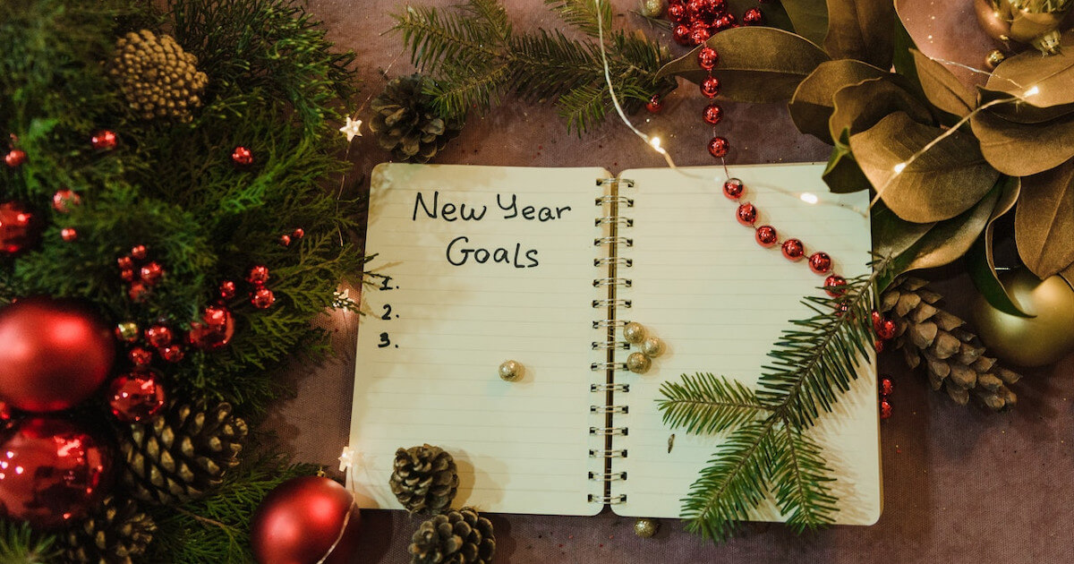 an insurance agent's notebook with the words "new year goals" written in it.