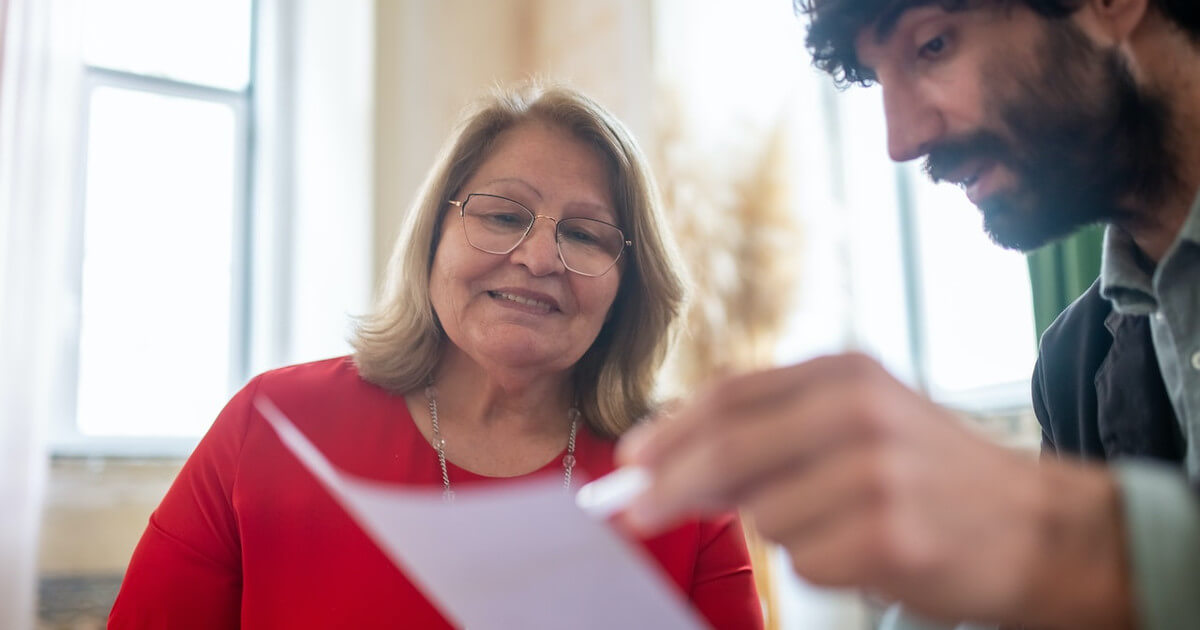 anticipating clients needs - man holding paper and older woman smiling by pexels-kampus-production