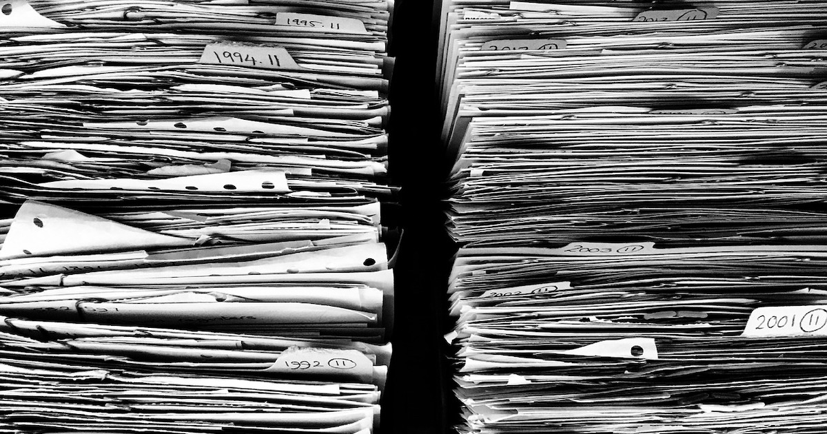 a stack of papers representing messy insurance agency management system data