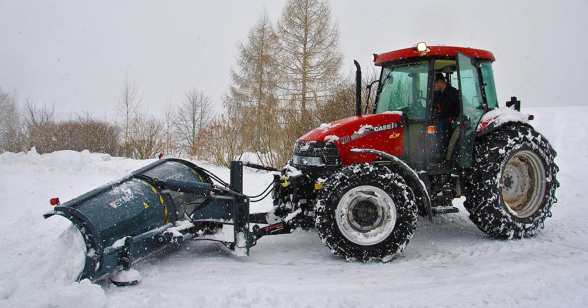 a tractor plowing snow after getting the right seasonal insurance policy